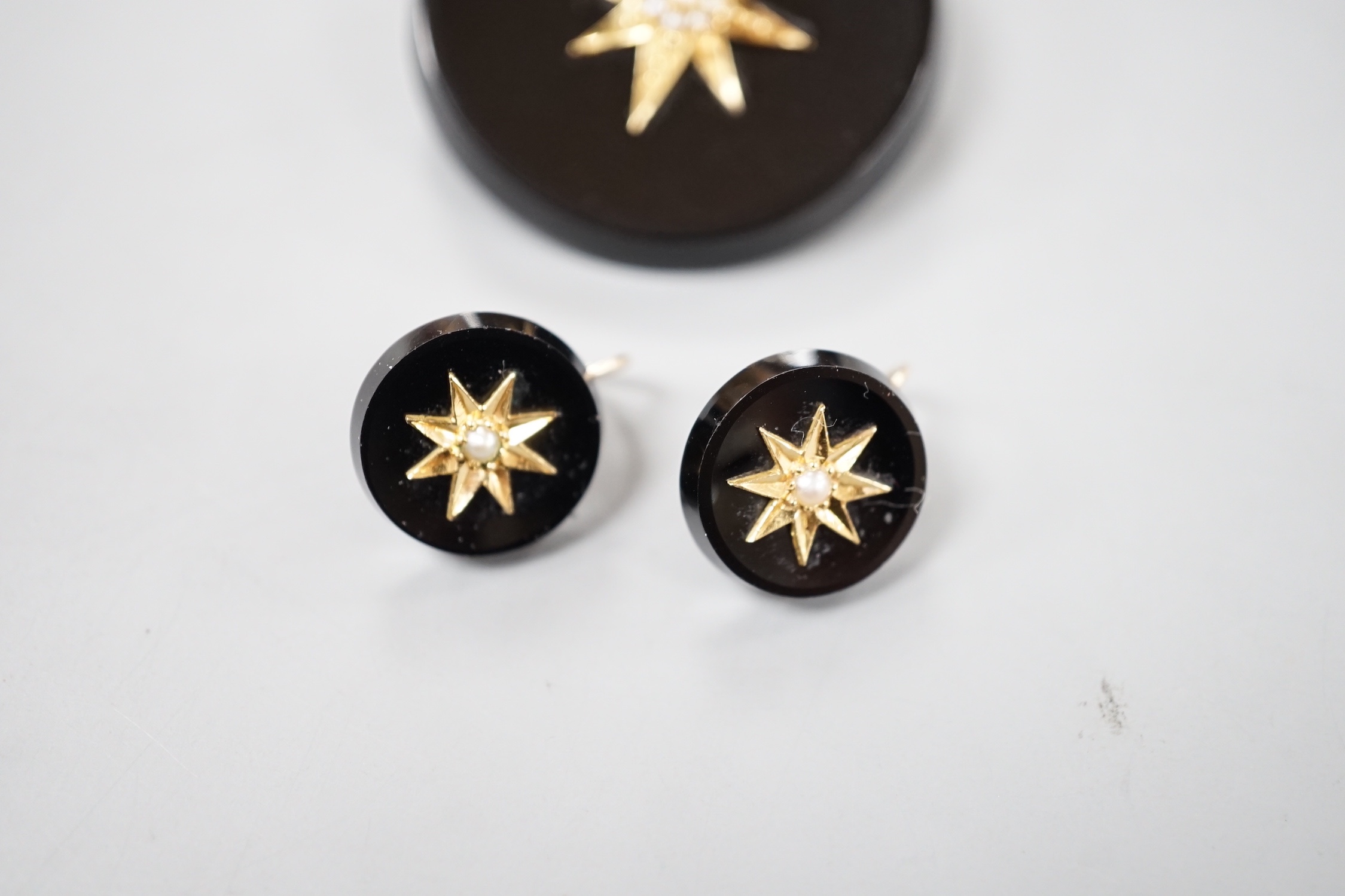 A late Victorian suite of yellow metal mounted black onyx and seed pearl mourning jewellery, coimprising a brooch, 33mm and pair of earrings.